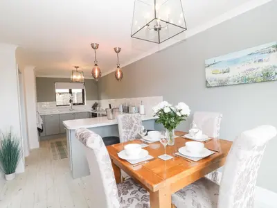a kitchen and dining room with a wooden table and chairs at 12 Claremont Falls in Looe