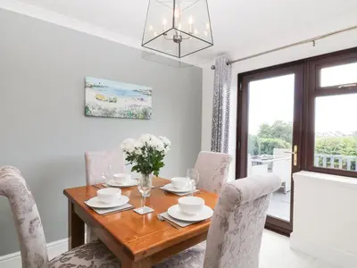 a dining room with a wooden table and chairs at 12 Claremont Falls in Looe