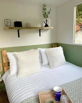 a bed with white sheets and pillows in a room at Trethowels Hidden Huts in St Austell