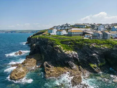 a group of houses on a cliff near the ocean at Gulland in Port Isaac