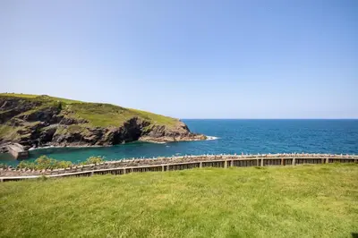 a bridge over a body of water next to the ocean at Gulland in Port Isaac