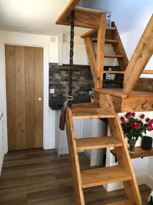 a wooden spiral staircase in a room with a door at Piala retreat in Phillack
