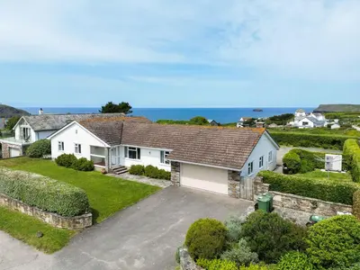 an aerial view of a house with the ocean in the background at Trebartha in Polzeath