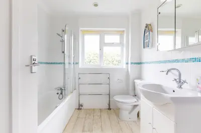 a white bathroom with a sink and a toilet at Trebartha in Polzeath