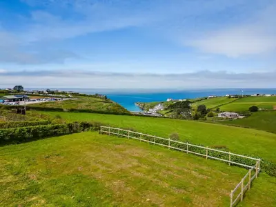 an open field with the ocean in the background at Stable Cottage in Port Isaac