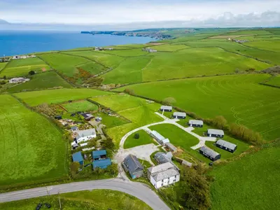 an aerial view of a farm near the ocean at Gull Lodge in Port Isaac