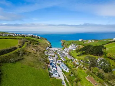 an aerial view of a village on a hill next to the ocean at Harbour Lodge in Port Isaac