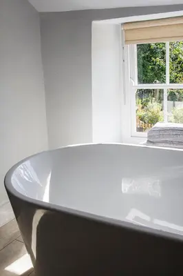 a bath tub in a room with a window at Cusgarne Manor boutique B&B - adults only in Cusgarne