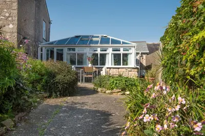 a conservatory with a glass roof in a garden at Laity Vean Hideaway - 2 Pets Allowed - Free Parking & WiFi in Carbis Bay