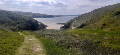 a path on a hill with a view of a body of water at Trewethen Cottage Barn 1 near Port Isaac in Port Isaac