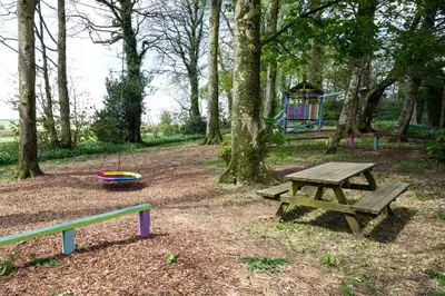 a park with a picnic table and a playground at Cornish Holiday - 91 Hengar Manor in Saint Tudy