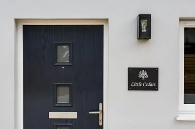 a black door with a sign on the side of a building at Little Cedars House in Truro