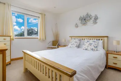 a bedroom with a large bed and a window at Breakers - Mount Brioni in Downderry