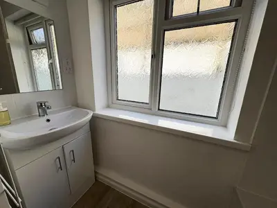 a bathroom with a sink and a window at Surf Watch - Mount Brioni in Downderry