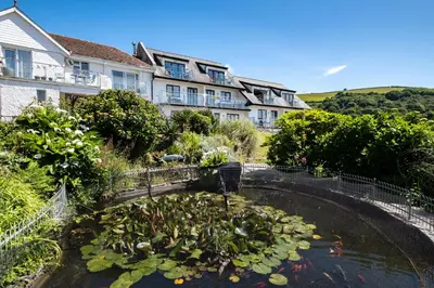 a koi pond in front of a building at Sand Bar - Mount Brioni in Downderry