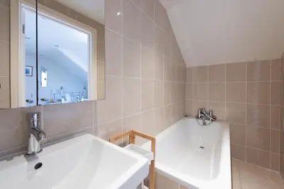 a bathroom with a tub and a sink and a window at Windsor Lookout in St Ives