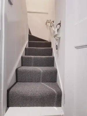 a stairway with a grey carpeted stair case at Malahne Apartment Port Isaac in Port Isaac