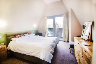 a bedroom with a bed and a television and a window at Lodges in Lanivet Cornwall with indoor pool in Bodmin