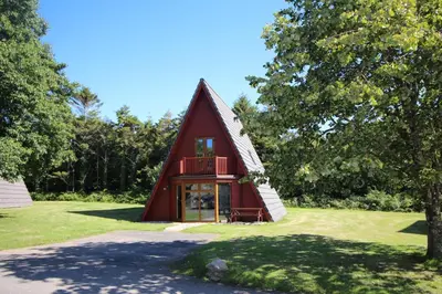 a red barn with a balcony in a field at Lodges in Lanivet Cornwall with indoor pool in Bodmin