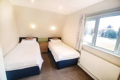 two beds in a small room with a window at Lodges in Lanivet Cornwall with indoor pool in Bodmin