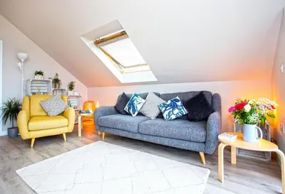 a living room with a blue couch and a yellow chair at The Neyth in Budock Water