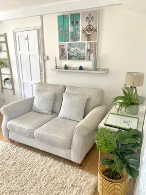 a living room with a couch and a table at Idyllic Cornish Cottage, Superking bed, private garden dogs welcome in Truro