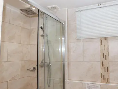 a shower with a glass door in a bathroom at Heron in St Ives
