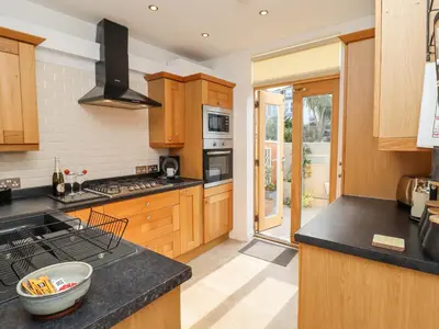 a kitchen with wooden cabinets and black counter tops at Whistler in St Ives