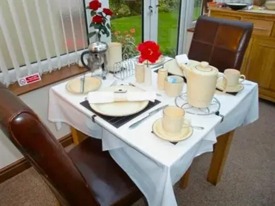 a white table with two chairs and a white table sidx sidx sidx at Eden's Rest Bed and Breakfast in St Austell