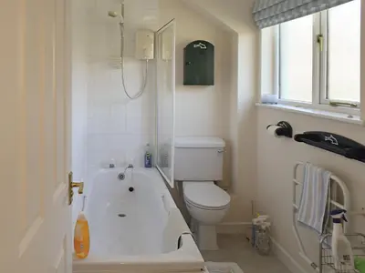 a bathroom with a bath tub and a toilet at Hazel Cottage in Budock Water