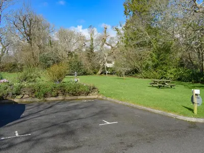 a parking lot with a picnic table and a park at Hazel Cottage in Budock Water