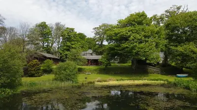 a house and a pond in front of a house at Ta Mill Cottages & Lodges - Olde Granary in Launceston