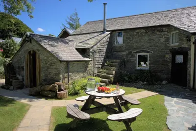 a picnic table in front of a stone house at Ta Mill Cottages & Lodges - Olde Granary in Launceston