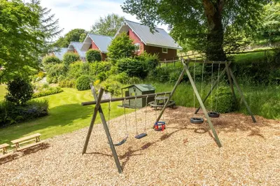 a playground with a swing set in a yard at Ta Mill Cottages & Lodges - Millers Cottage in Launceston
