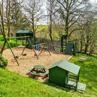 a playground with a picnic table and a swing at Ta Mill Cottages & Lodges - Smithy Cottage in Launceston