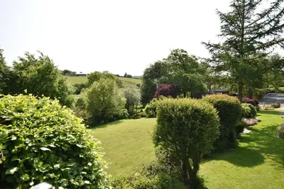 a garden with bushes and trees and a tree at Ta Mill Cottages & Lodges - Meadowview Chalet 4 in Launceston