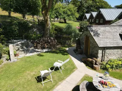 an aerial view of a garden with two chairs and a building at Ta Mill Cottages & Lodges - Meadowview Chalet 4 in Launceston
