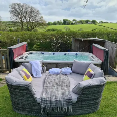 a table and chairs in front of a hot tub at Ta Mill Cottages & Lodges - Brookview Lodge 1 in Launceston