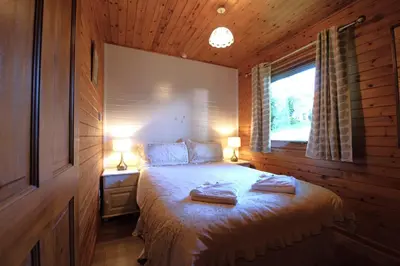 a bedroom with a bed with two towels on it at Ta Mill Cottages & Lodges - Brookview Lodge 2 in Launceston
