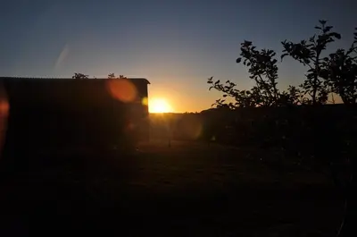 a sunset in a field with a truck at Shepherds hut with valley views in Bodmin