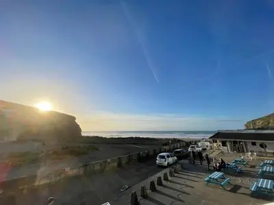 a view of the sun setting over the ocean at Whispering Waves in Porthtowan, Beachfront Apartment in Porthtowan