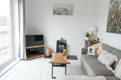a living room with a couch and a tv at Hoblyns Cove in Holywell Bay