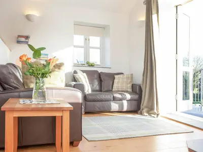 a living room with a couch and a table at Old Dairy - Uk36514 in Germoe