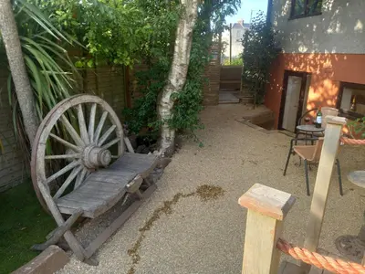 a wooden bench sitting next to a building with a wheel at Crofty's Celder - Uk35181 in Pool