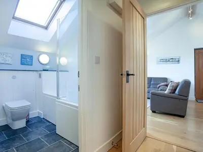 a bathroom with a toilet and a couch at The Hayloft - Uk36516 in Germoe