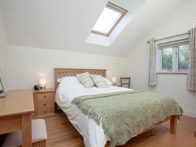 a bedroom with a bed and a desk and a window at The Hayloft - Uk36516 in Germoe