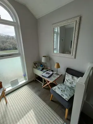 a living room with a chair and a mirror at 1 Bed Cottage - Sleeps 2 - Parking - Wifi in Truro