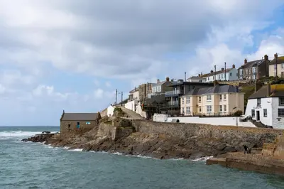 a group of houses on a cliff next to the ocean at Finest Retreats - The Hideaway - Studio Apartment in Porthleven in Porthleven