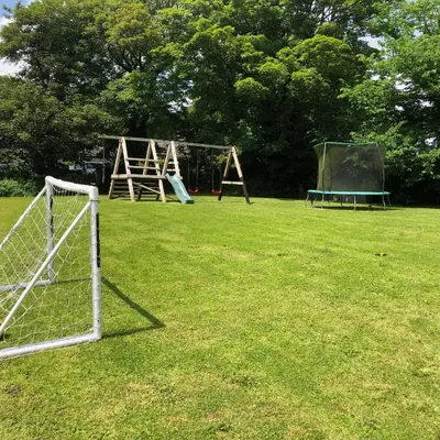 a field with a soccer goal and a playground at Coverack in Budock Water