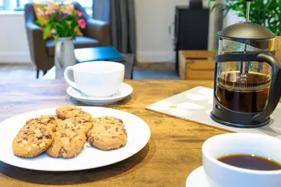 a plate of cookies and a cup of coffee on a table at Porthallow in Budock Water